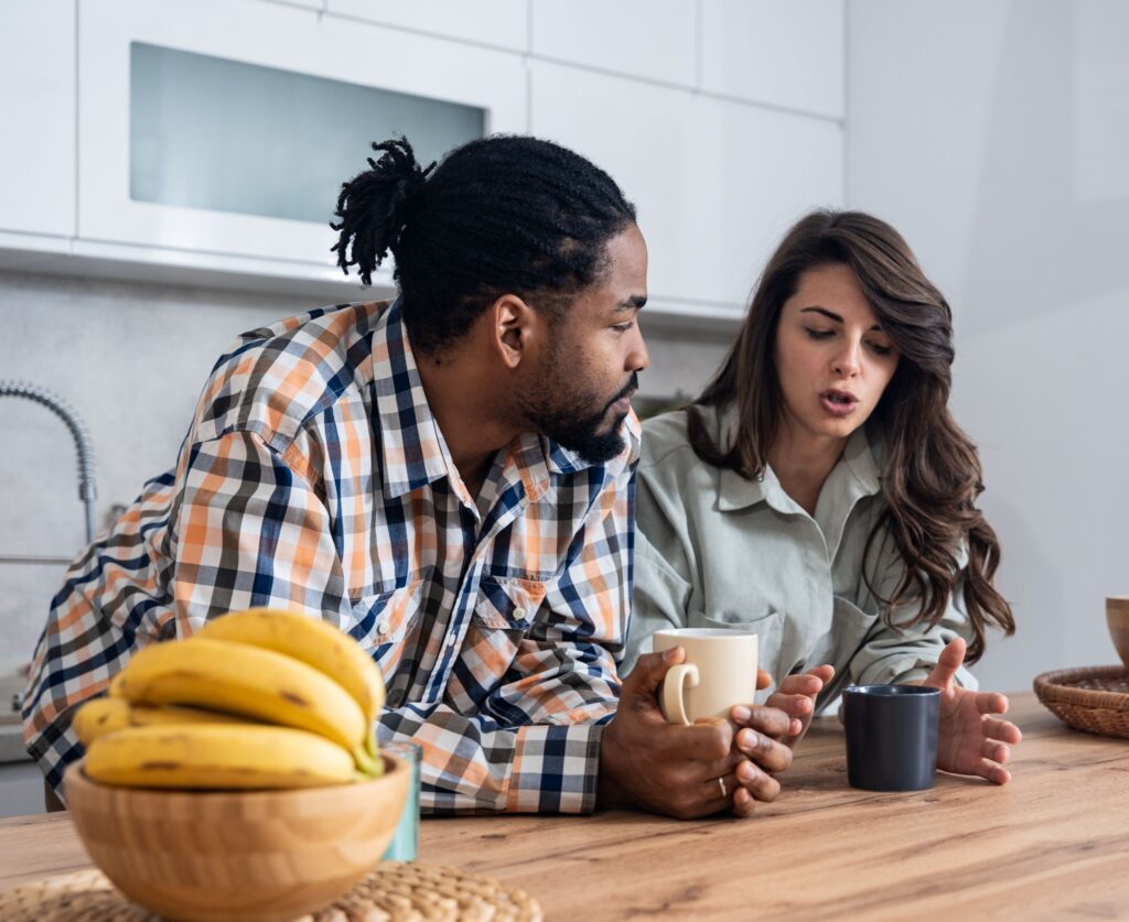 A man and woman discuss health in a kitchen.