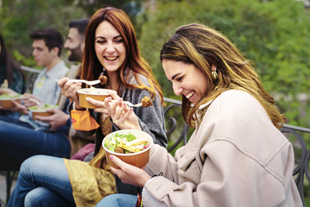 Friends eat salad outside